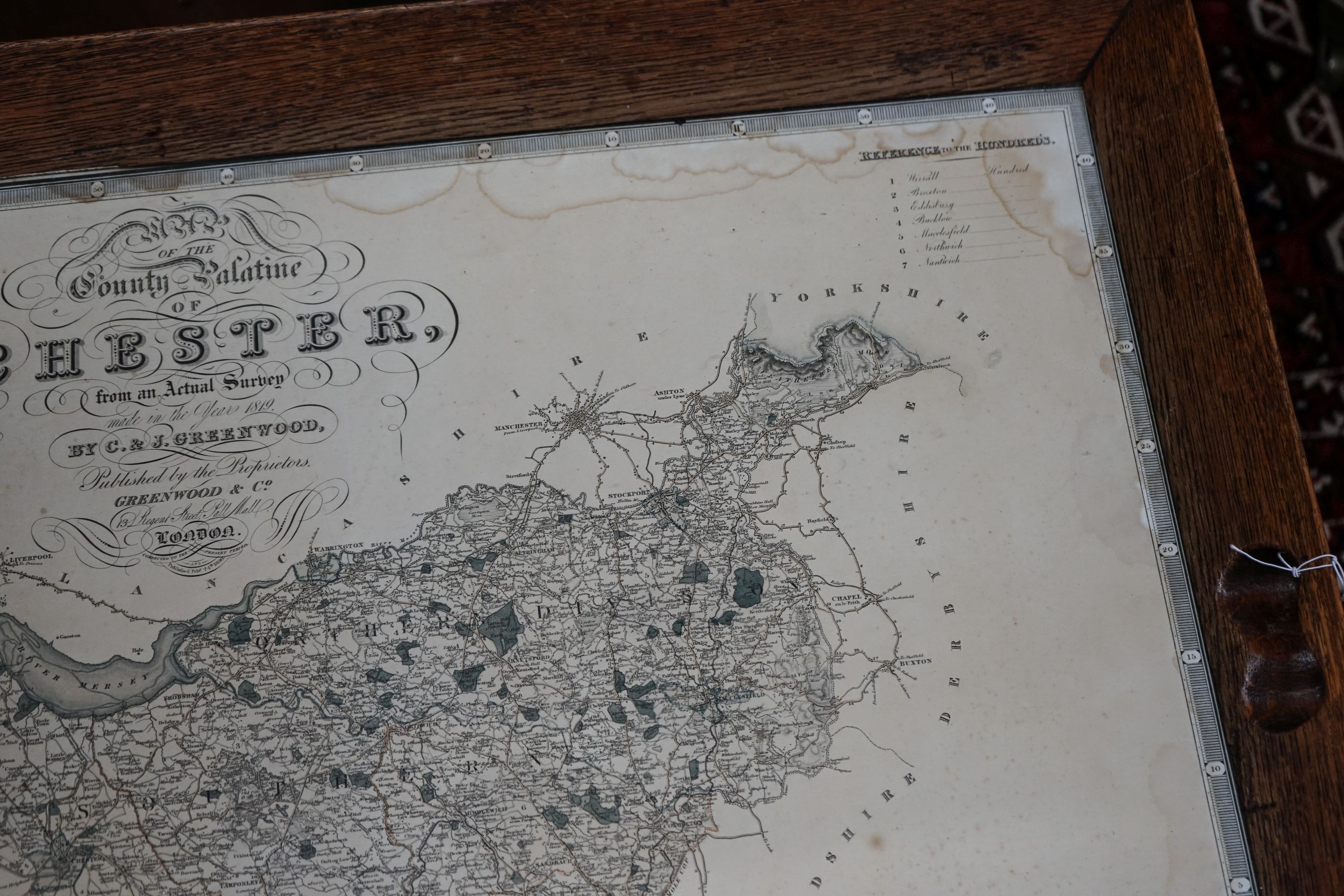 A rectangular oak tray top low table inset with a map of Cheshire on ball and claw stand, width 80cm, depth 70cm, height 48cm